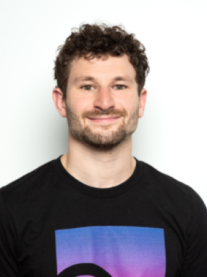 Smiling guy in black Embr Labs shirt against white background.